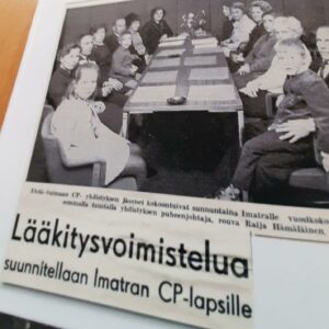 Mustavalkoinen kuva, jossa paljon ihmisiä pöydän ääressä, alla teksti: Lääkitysvoimistelua suunnitellaan Imatran CP-lapsille